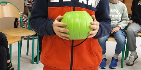 Powiększ grafikę: Chłopiec z 3c trzyma miseczkę z  napisanymi wróżbami na karteczkach.