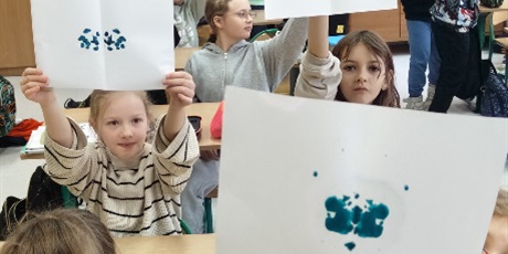 Powiększ grafikę: Dzieci z 3c pokazują wróżby z tuszem na kartkach. 