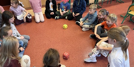 Powiększ grafikę: Dzieci z kl.1b turlają wróżby kostkami.