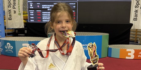 Powiększ grafikę: Zawodniczka z medalami i statuetką.