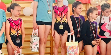Powiększ grafikę: Dziewczynki stoją na podium zawodów.
