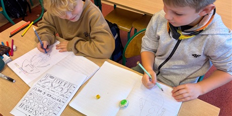 Powiększ grafikę: Uczniowie w ławce rysują robota wg kodu.