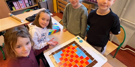 Powiększ grafikę: Dzieci prezentują ułożone piksele.