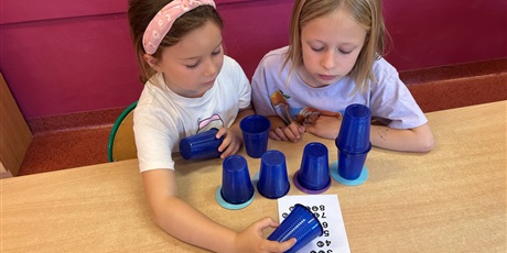 Powiększ grafikę: Dzieci ustawiają wieże z kubków.