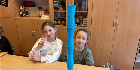 Powiększ grafikę: Dzieci ustawiają wieże z kubków.