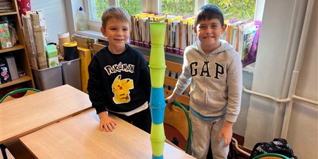 Powiększ grafikę: Dzieci ustawiają wieże z kubków.