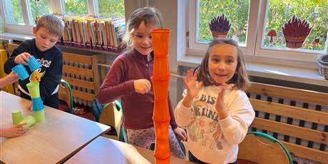 Powiększ grafikę: Dzieci ustawiają wieże z kubków.