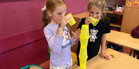 Powiększ grafikę: Dzieci ustawiają wieże z kubków.