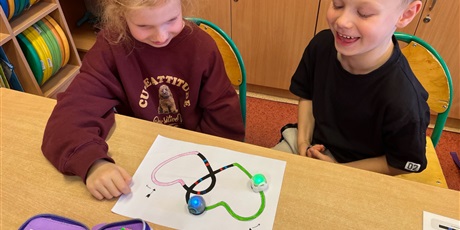 Powiększ grafikę: Dzieci obserwują zaprogramowane przez nich ozoboty.