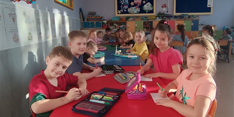 Powiększ grafikę: Dzieci przy stolikach  ozdabiają kartki świąteczne.