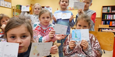 Powiększ grafikę: Dzieci  z klasy 1c w trakcie wykonywania kartek z  życzeniami świątecznymi.