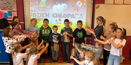 Powiększ grafikę: Dziewczynki z kl.2b wskazują kciukiem na super chłopców.