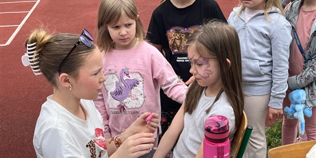 Powiększ grafikę: Uczennica maluje dziewczynce twarz