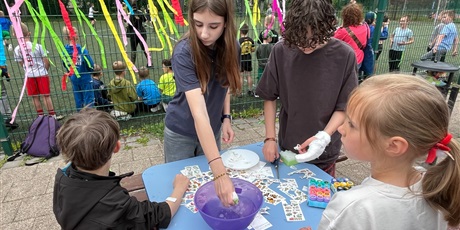 Powiększ grafikę: Uczennice przyklejają dzieciom tatuaże.