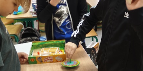 Powiększ grafikę: Trzech uczniów z klasy 3c gra w planszówkę "Gorący ziemniak". 