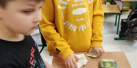 Powiększ grafikę: Dwóch uczniów z klasy 3c gra w karty "Psia kość". 