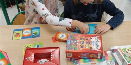 Powiększ grafikę: Dwie dziewczynki grają w planszówkę.