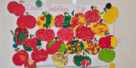 Powiększ grafikę: na białej tablicy przypięte są prace plastyczne dzieci jabłka z wydzieranki z kolorowego papieru