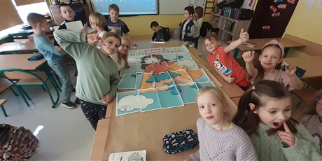 Powiększ grafikę: Dziewczynki z klasy 1c  układają puzzle XXL z rysunkiem i napisem "Super Dziewczyna".