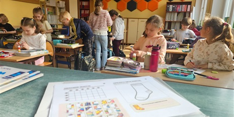 Powiększ grafikę: Dzieci z klasy 2c rozwiązują karty pracy o tematyce związanej z Dniem Skarpetki.