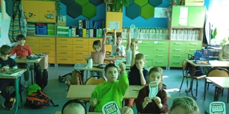 Powiększ grafikę: Dzieci z kl.1a prezentują narysowane kolorowe skarpetki.