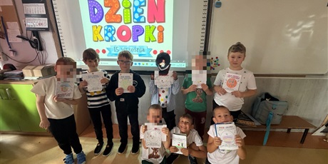 Powiększ grafikę: Chłopcy pozują do zdjęcia z wykonanymi przez siebie kropkami. 