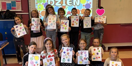 Powiększ grafikę: Dzieci z kl.2b w dwóch rzędach prezentują swoje kropkowe prace.