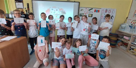 Powiększ grafikę: Uczniowie kl.3a w dwóch rzędach prezentują narysowane swoje talenty.
