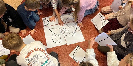 Powiększ grafikę: Dzieci z kl.1b składają misia xxl z puzzli.