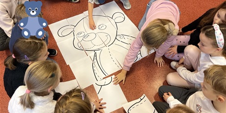Powiększ grafikę: Dzieci z kl.1b składają misia xxl z puzzli.