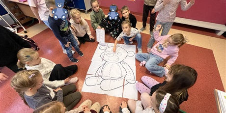 Powiększ grafikę: Dzieci z kl.1b składają misia xxl z puzzli.