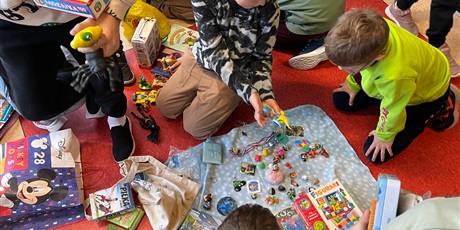 Powiększ grafikę: Uczniowie na holu wymieniają się przyniesionymi przedmiotami.