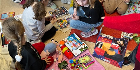 Powiększ grafikę: Uczniowie na holu wymieniają się przyniesionymi przedmiotami.