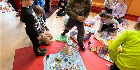 Powiększ grafikę: Uczniowie na holu wymieniają się przyniesionymi przedmiotami.