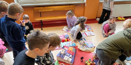 Powiększ grafikę: Uczniowie na holu wymieniają się przyniesionymi przedmiotami.