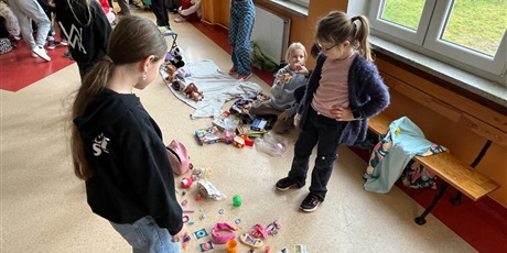 Powiększ grafikę: Uczniowie na holu wymieniają się przyniesionymi przedmiotami.