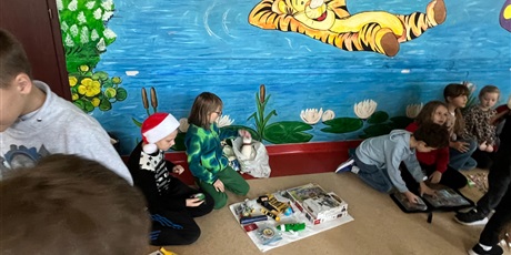 Powiększ grafikę: Uczniowie na holu wymieniają się przyniesionymi przedmiotami.