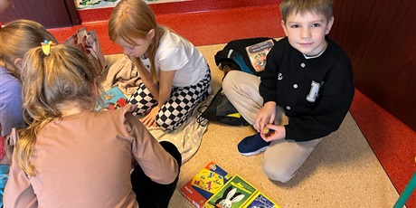 Powiększ grafikę: Uczniowie na holu wymieniają się przyniesionymi przedmiotami.