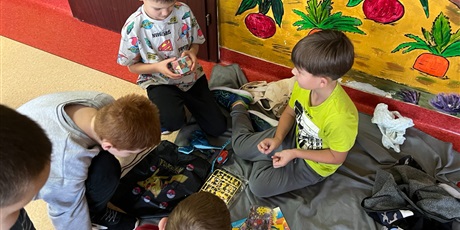 Powiększ grafikę: Uczniowie na holu wymieniają się przyniesionymi przedmiotami.