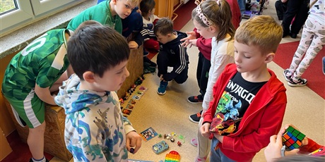 Powiększ grafikę: Uczniowie na holu wymieniają się przyniesionymi przedmiotami.