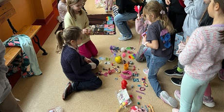 Powiększ grafikę: Uczniowie na holu wymieniają się przyniesionymi przedmiotami.