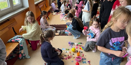 Powiększ grafikę: Uczniowie na holu wymieniają się przyniesionymi przedmiotami.