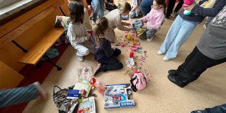 Powiększ grafikę: Uczniowie na holu wymieniają się przyniesionymi przedmiotami.