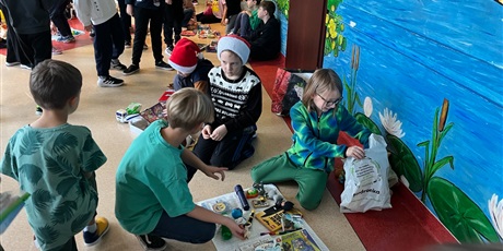 Powiększ grafikę: Uczniowie na holu wymieniają się przyniesionymi przedmiotami.