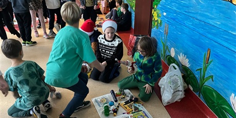 Powiększ grafikę: Uczniowie na holu wymieniają się przyniesionymi przedmiotami.