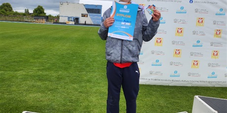 Powiększ grafikę: zawodnicy stoja na podium z medalami na szyi i dyplomami w ręku