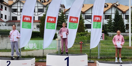 Powiększ grafikę: zawodnicy stoja na podium z medalami na szyi i dyplomami w ręku