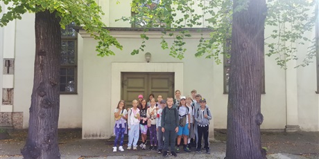 Powiększ grafikę: uczniowie stoją przy wejściu do dawnego zboru mennonitów