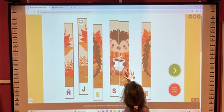 Powiększ grafikę: Uczennica składa z puzzli jeża.