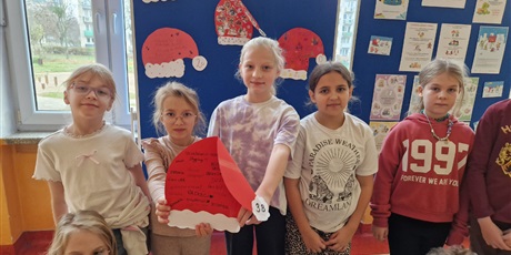 Powiększ grafikę: Czapka dla Mikołaja przygotowana przez kl.3b zawieszona na tablicy.